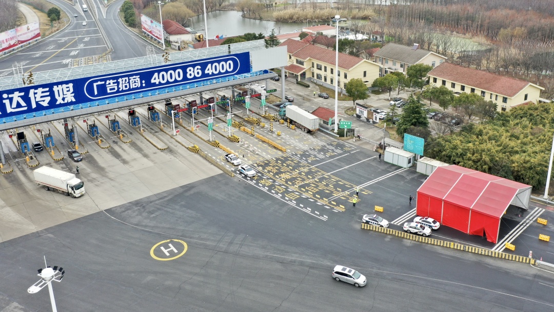 2月18日早上7点50分,在陆家收费站,记者看到交通部门,交警,志愿者等10